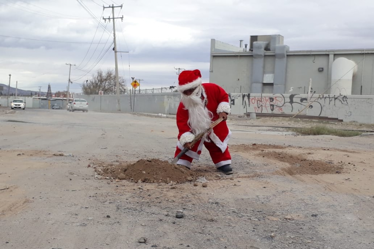 Mini Santa Claus tapa baches de la ciudad 
