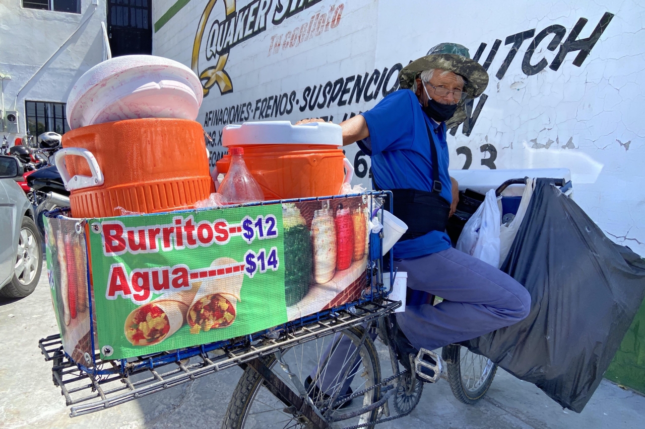 En bicicleta Don Manuel ofrece burritos y aguas frescas en la Ejército Nacional