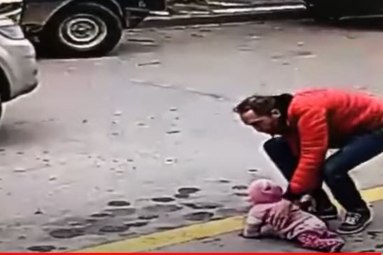 Bebé intenta cruzar la calle gateando mientras pasan autos