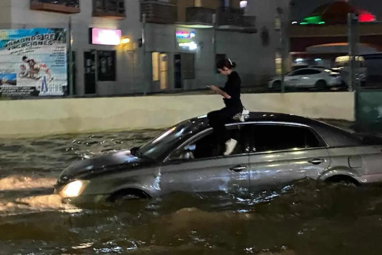 Juárez: Mujer queda varada en inundación y se sube a auto para resguardarse