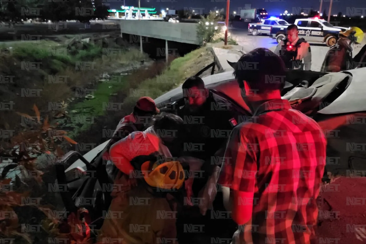 Queda carro a punto de caer a acequia tras choque