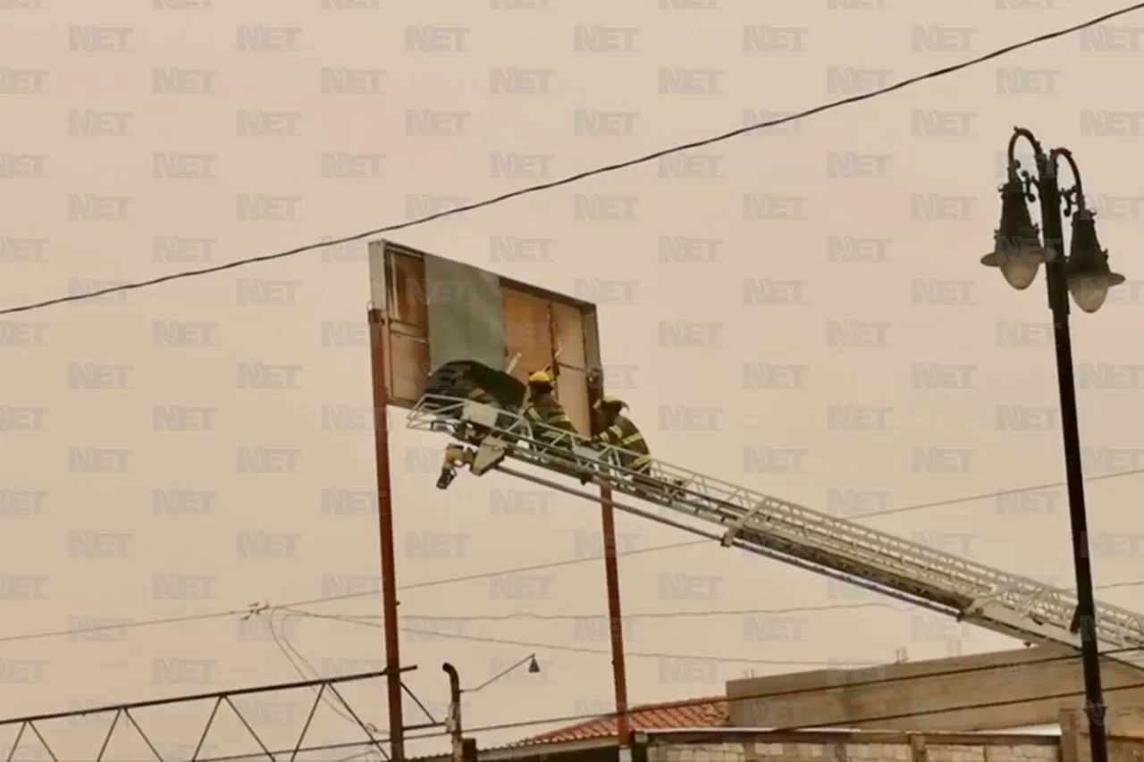 Bomberos retiran láminas de espectacular ante fuertes vientos