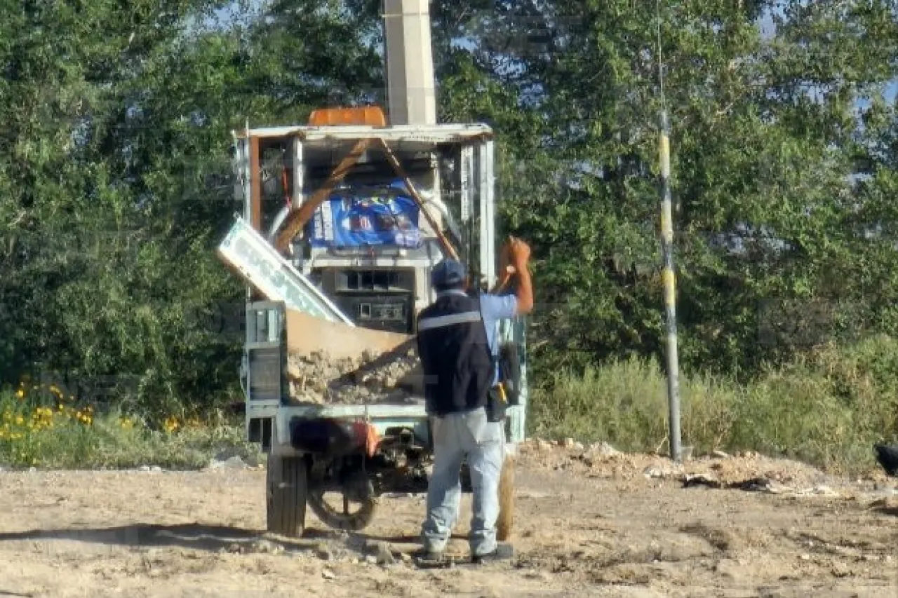 Frente a municipales tira escombro desde triciclo; lo obligan a recogerlo